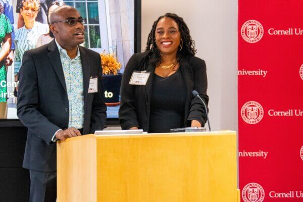 Neil Lewis, Jr. (on the left) and Tashara Leak (on the right) speak at a dias.